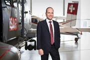 Ruag-CEO Urs Breitmeier postiert in Emmen vor einem Superpuma und einem Pilatusporter. Bild: Manuela Jans-Koch (Emmen, 20. März 2014)