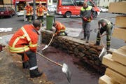 Einsatzkräfte der Feuerwehr schaufeln Öl. (Bild Kantonspolizei Schwyz)
