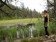 Janine Heini wirft ein Stück Holz in den Pilatussee. Im Mittelalter wäre sie dafür noch verhaftet worden, weil die Luzerner glaubten, dass die Totenruhe des Pontius Pilatus dadurch gestört würde. (Bild: PD)