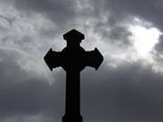 Ein Kreuz vor dunklen Wolken (Symbolbild) (Bild: Keystone)