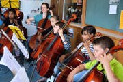 Mitglieder des Orchesters BaBeL-Strings bei einer Probe im Luzerner St.-Karli- Schulhaus. Mitgründerin Graziella Carlen spielt im Hintergrund mit. (Bild Nadia Schärli)