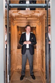 CEO Thomas Oetterli (46) in einem holzverkleideten Schindler-Lift. Bild: Roger Grütter (Ebikon, 26. Oktober 2016)