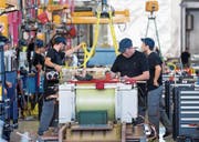 Arbeiter im Werk von ABB Sécheron auf der Produktionslinie für Transformatoren. (Bild: Salvatore Di Nolfi/Keystone (Satigny, 20. Februar 2015))