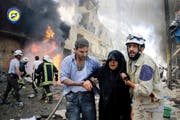 Helfer begleiten eine Frau aus den Trümmern nach einem Luftangriff in der syrischen Stadt Aleppo am 8. Juni 2016. (Bild: AP)