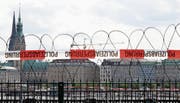 Stacheldraht wurde installiert, um Demonstranten am G20-Gipfel in Hamburg in Schach zu halten (oben). Beim Treffen, das Spannungen verspricht, sind unter anderem dabei: Der türkische Präsident Recep Tayyip Erdogan, die deutsche Kanzlerin Angela Merkel, US-Präsident Donald Trump, Russlands Präsident Wladimir Putin, Frankreichs Präsident Emmanuel Macron und der chinesische Präsident Xi Jinping (von links). (Bilder: EPA/Keystone)