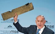 Der israelische Ministerpräsident Benjamin Netanjahu hält während seiner Rede ein Teil einer abgeschossenen iranischen Drohne in die Luft. (Bild: EPA (München, 18. Februar 2018))