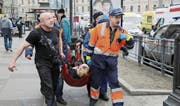 Rettungskräfte eilen einem Opfer der Anschläge zu Hilfe. (Bild: Anton Vaganow/EPA (Sankt Petersburg, 3. April 2017))