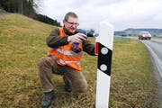 Lukas Suter, Sektionspräsident Seetal des Verbandes Revierjagd Luzern, montiert ein Wildwarnsignal. (Bild: Corinne Glanzmann / Neue NZ)