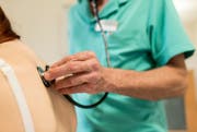 Ein Arzt hört bei einer Patientin die Lunge mit einem Stethoskop ab (gestellte Szene). (Bild: Christian Beutler/Keystone)