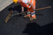 Ein Bauarbeiter bei Belagsarbeiten. (Symbolbild Keystone)