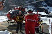 Der Rega-Helikopter steht bereit, während Ärzte einen Patienten verladen. (Bild: Christoph Riebli / Neue LZ)