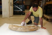 Daniel Imfeld, Mitarbeiter bei der Kantonsarchäologie, reinigt den Mammutzahn. (Bild: PD)