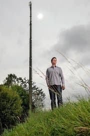 Der Bauer Daniel Muff vor einer Antenne der Swisscom, die auf seinem Gelände steht. Fotografiert am 15. September 2016 in Schlierbach. (Bild: Eveline Beerkircher / LZ)
