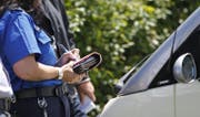 Eine Polizeiassistentin stellt eine Ordnungsbusse aus. (Symbolbild ZZ)