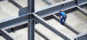 Ein Bauarbeiter geht seiner Arbeit nach.Bild: Steffen Schmidt/Keystone (Kloten, 12. Juli 2012)