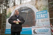 Peter Bigler (FDP), Gemeindepräsident von Wolhusen, vor dem Plakat des geplanten des Tunnels. (Bild: Boris Bürgisser (Wolhusen, 28. November 2017))