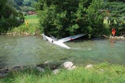 Einsatzkräfte sichern den Segelflieger in der Sarneraa mit Seilen. (Bild: Polizei Obwalden)