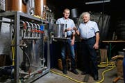 Hermann (r.) und Armin Röllin prosten sich mit einem preisgekrönten Destillat aus ihrer Brennanlage zu. (Bild: Stefan Kaiser)