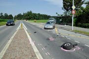 Räder und Trümmerteile der schrottreifen Autos liegen auf der Sinserstrasse. (Bild: Zuger Polizei)