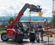 Mit (vermeintlicher) Grobmotorik gezielt Wasser in einen Trichter giessen – in Steinhausen zeigen Könner ihre Fertigkeiten am Steuer der gewichtigen Landmaschinen. (Bild: Maria Schmid (20. August 2017))