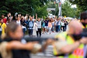 Durch Polizisten mit Waffen abgeschirmt, verlassen unzählige Menschen am Freitagabend das Olympia-Einkaufszentrum in München. (Bild: AFP)