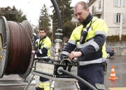 Mitarbeiter von ewl beim Einzug von Glasfaserkabeln. (Bild pd)