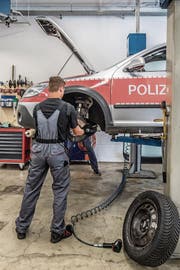 Ein Mitarbeiter wechselt in der Polizeiwerkstatt Bremsscheiben aus. (Bild: Nadia Schärli (Emmen, 24. August 2017))