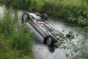 Das Auto landete auf dem Dach m Kanal. (Bild: Zuger Polizei)