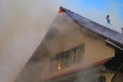 Flammen dringen aus dem Dachstock des Bauernhauses. (Bild: Luzerner Polizei)