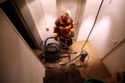 Mit einer Tauchpumpe und einem Wassersauger wird das Wasser aus einem Kellerraum in Oberwil abgepumpt. (Bild: Feuerwehr Zug)