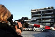 Eine Reporterin filmt den Tatort beim Penthouse am Eschenring in Zug. (Bild Werner Schelbert)