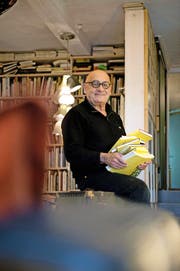 Tino Steinemann (70) mit einem von über 200 Reiseskizzenbüchern in seinem Zuhause in Neuenkirch. (Bild Dominik Wunderli)