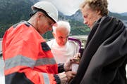 Renzo Simoni, Vorsitzender der Geschäftsleitung der Alptransit Gotthard AG, Martin Kopp, Generalvikar für die Urschweiz, und Reinhard Eisner, Pfarrer der evangelisch reformierten Landeskirche Uri (von links) zünden eine Kerze an und gedenken den neun verstorbenen Mineuren. (Bild: Keystone / Gaetan Bally)