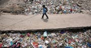 Spuren der Wegwerfgesellschaft: Ein Junge passiert auf seinem Schulweg in der indischen Hauptstadt Neu-Delhi eine Mülldeponie. (Rajat Gupta/AP, 22. April 2017)