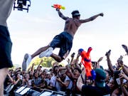 Musiker und Besucher liessen sich am Openair Frauenfeld von der grossen Hitze nicht die Stimmung vermiesen - Rapper Sidney Royel Selby III alias Desiigner stürzte sich am Donnerstag samt Wasserpistole ins Publikum. (Bild: KEYSTONE/NICK SOLAND)