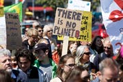 Die Teilnehmer des Marsches machen mit Transparenten auf ihre Anliegen aufmerksam. (Bild: Salvatore Di Nolfi / Keystone (Genf, 29. April 2017))