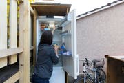 Eine Studentin nimmt Nahrungsmittel aus einem öffentlichen Kühlschrank im Hinterhof des Lola-Ladens, am Mittwoch, 8. April 2015 in Bern. (Bild: Keystone/ Peter Klaunzer)