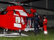 Ein Mitarbeiter der Schwyzer Polizei (links) macht sich bereit für den Flug im Rega-Heli. (Bild: Geri Holdener)