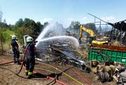 Feuerwehrleute löschen den Brand in der Scheune Weidhof in Zug. (Bild: Stefan Kaiser / Neue ZZ)