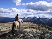 Nicole Ulrich auf ihrem Pferd vor der imposanten Kulisse der blauen Berge der Monashee Mountain Range bei Clearwater in Kanada. (Bild: PD)