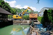 Das grosse Aufräumen: Ein Bagger lädt beim Seeufer Sand und Geröll auf einen Lastwagen. (Bild Corinne Glanzmann)
