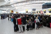 Passagiere stehen vor den Check-In Schaltern am Londoner Flughafen Heathrow Schlange. (Bild: Keystone)