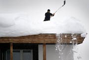 Ein Angehöriger der Polizei befreit das Dach des Kongress Hotels neben dem Kongresszentrum in Davos, wo derzeit das WEF stattfindet, von Schnee. (Bild: Laurent Gillieron (Davos, 22. Januar 2017))