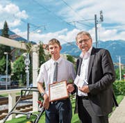 Fabio Setto mit seinem Arbeitsgerät (Rasenmäher) und Bildungsdirektor Franz Enderli, aus dessen Händen er das Diplom im Hüetli-Garten erhält. (Bild: Christoph Riebli (Sarnen, 4. Juli 2017))