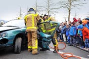 «Wasser Marsch»: Nino (2) aus Sachseln mit Maschinist Martin Imfeld in Aktion. Rechts verfolgen die vielen Kinder gespannt, wie die Strassenretter sich mit Spreizer und Schneidwerkzeug an einem Unfallauto zu schaffen machen. (Bilder Christoph Riebli)