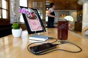 Ein Handy wird im Restaurant über einen portablen Akku geladen. (Bild: Corinne Glanzmann)