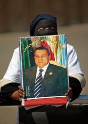 Eine Unterstützerin hält während eines Protests ein Porträt von Ägyptens Ex-Präsident Hosni Mubarak. (Bild: Khalil Hamra/AP (Kairo,)
