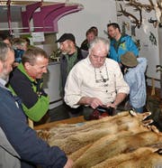 Links: Das Interesse an der Trophäenschau ist bei allen Altersgruppen gross; rechts: Beim Pelzfellmarkt wird immer wieder um gute Preise gekämpft. (Bilder: Archiv Urner Zeitung)