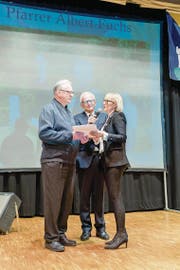 Judith Odermatt überreicht Albert Fuchs ein Präsent für sein «Lebenswerk», in der Mitte Speaker Sepp Odermatt. (Bild: Daniel Diggelmann/PD (Oberdorf, 20. Januar 2018))