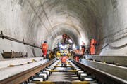 Bauarbeiter richten im Gotthard-Basis-Tunnel die Schienen, bevor sie mit Betonieren beginnen können. (Bild: Keystone/Christian Beutler)